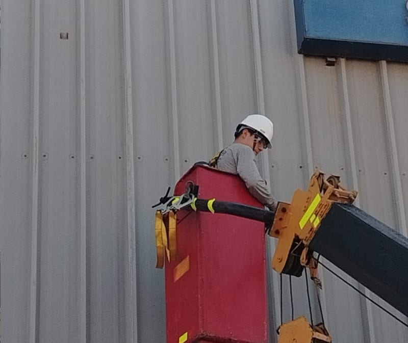 Trabajador en canastilla instalando señalética en altura - Arcring Perú