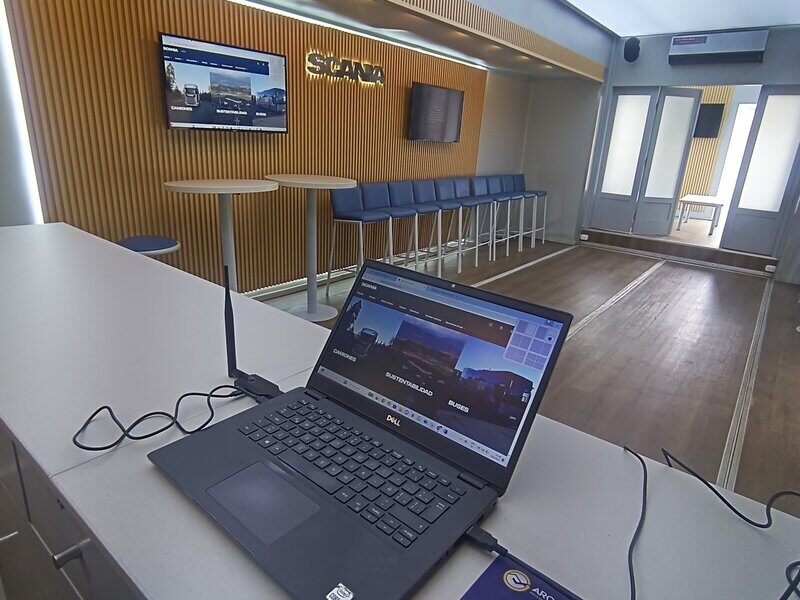 Showroom interior con pantalla SCANIA, laptop y sillas - SCANIA DemoTruck Arcring